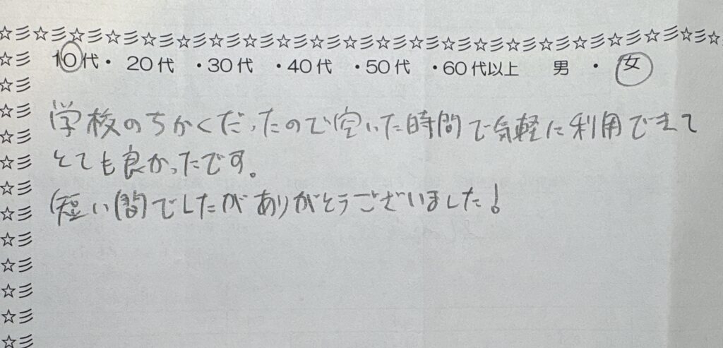 アンケート用紙に手書きで「学校の近くだったので空いた時間で気軽に利用できてとても良かったです。短い間でしたがありがとうございました！」と書かれたコメント。10代・女性の利用者が、自習室やコワーキングスペースを短時間利用した感想を記入している様子。